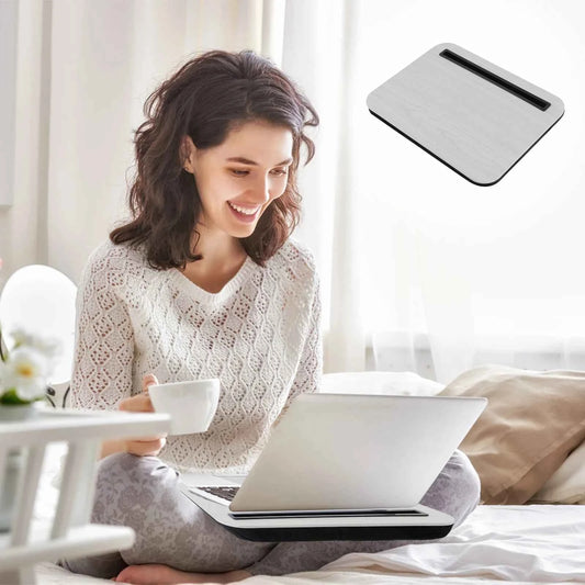 Woman using a laptop with a cooling pad on a bed