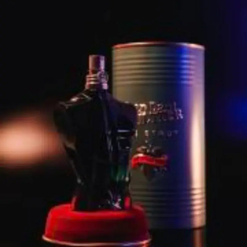 Jean Paul Gaultier Le Beau Eau de Parfum bottle in black torso shape with decorative canister on dark background.
